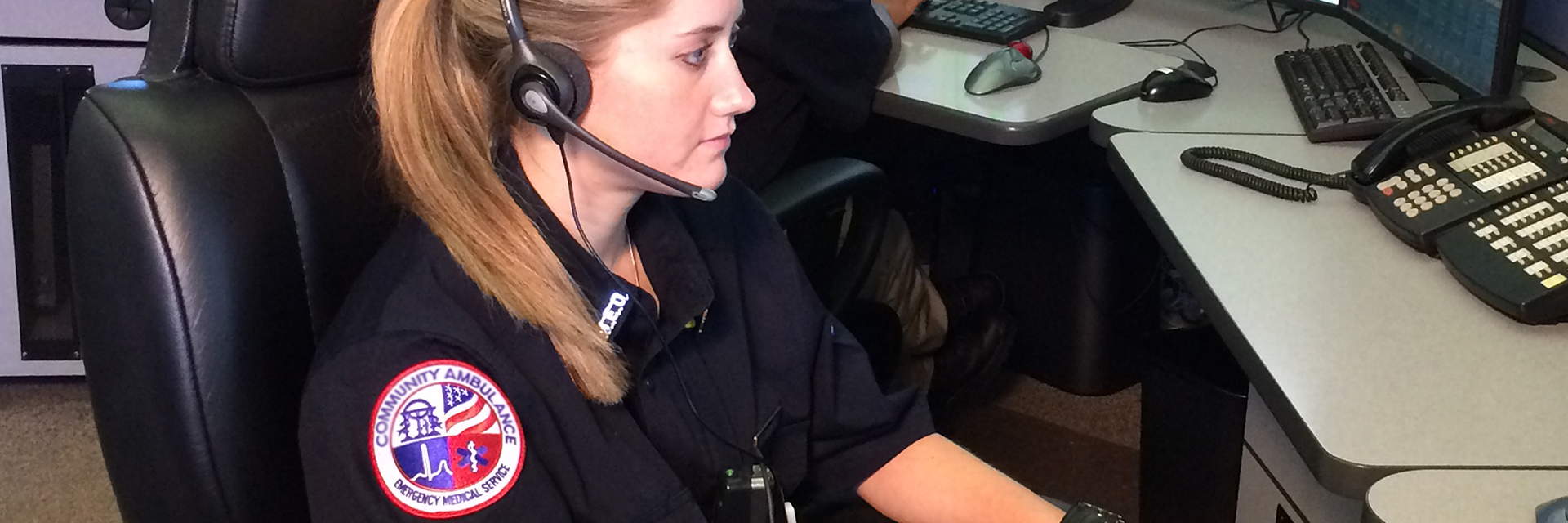 Female EMT sitting at desk in call center